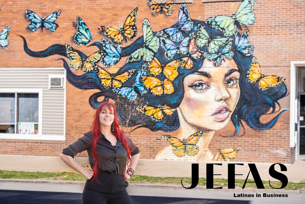 Mujer sonrisa frente mural de mariposas